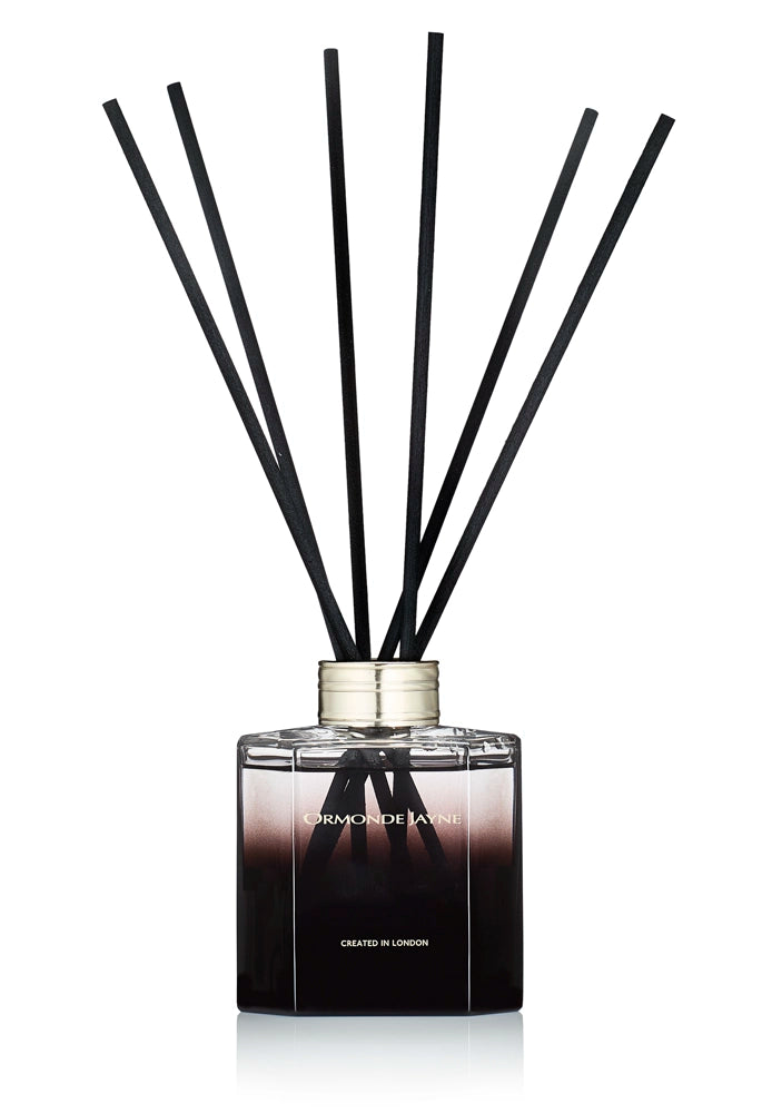 Black and clear glass reed diffuser bottle with black fragrance sticks, peony scent