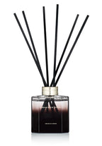 Black and clear glass reed diffuser bottle with black fragrance sticks, peony scent