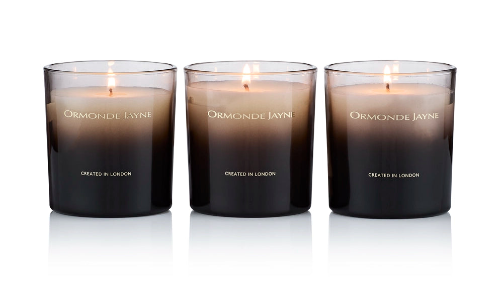 Set of three lit scented candles in gradient black to amber glass holders with Ormonde Jayne branding