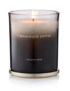 Lit Champaca scented candle in a frosted black glass holder with gold base and lettering