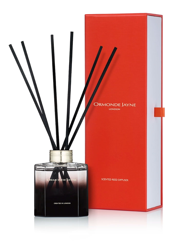 Ormonde Jayne scented reed diffuser with black gradient glass bottle and black reeds, beside red and white packaging box