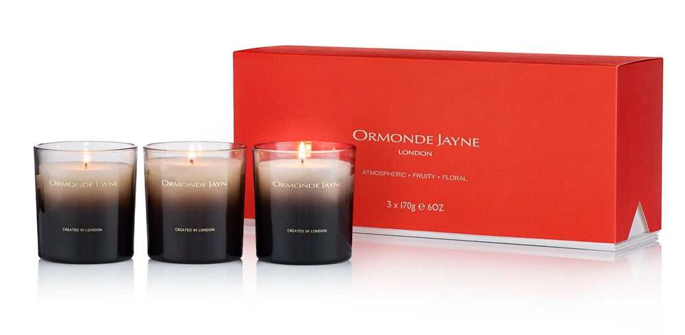 Set of three black and white gradient scented candles with floral fragrance in front of red Ormonde Jayne London box