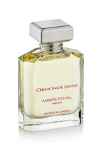 Clear glass perfume bottle with silver cap containing pale amber liquid, labelled Ambre Royal