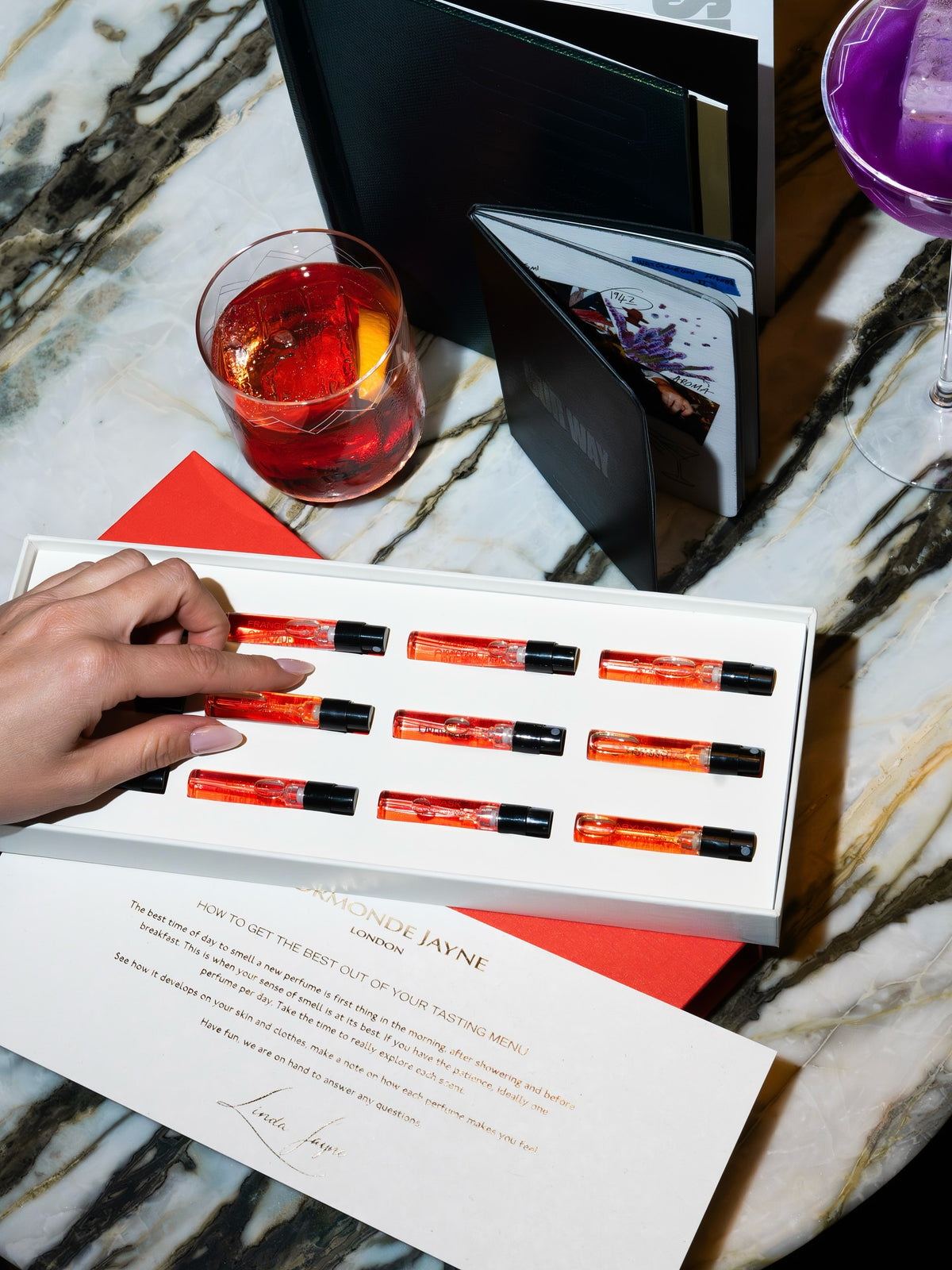 Tasting Menu vials in the white tray with the descriptive menu card