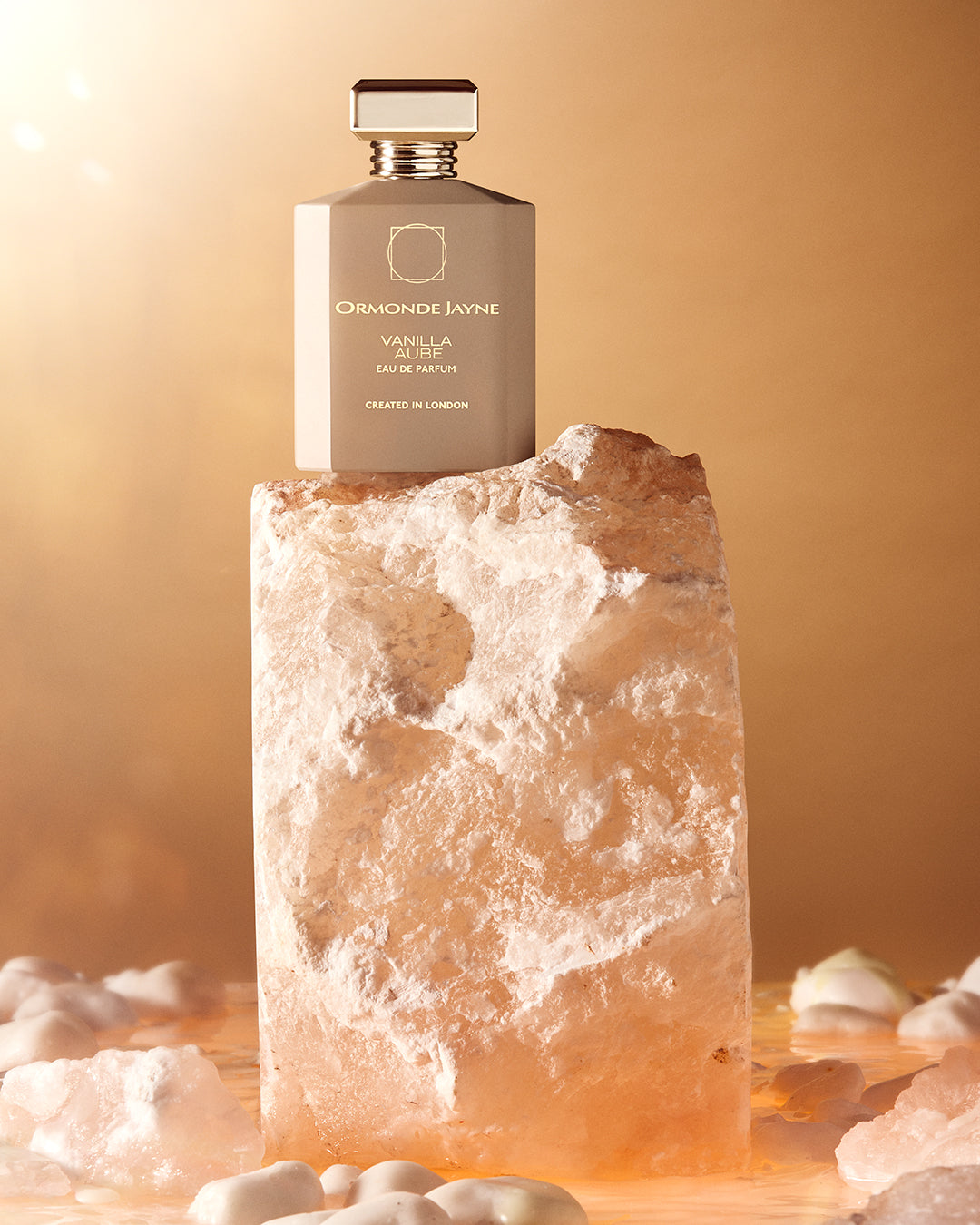 Vanilla Aube bottle on pink Himalayan salt in dawn light, four by five crop