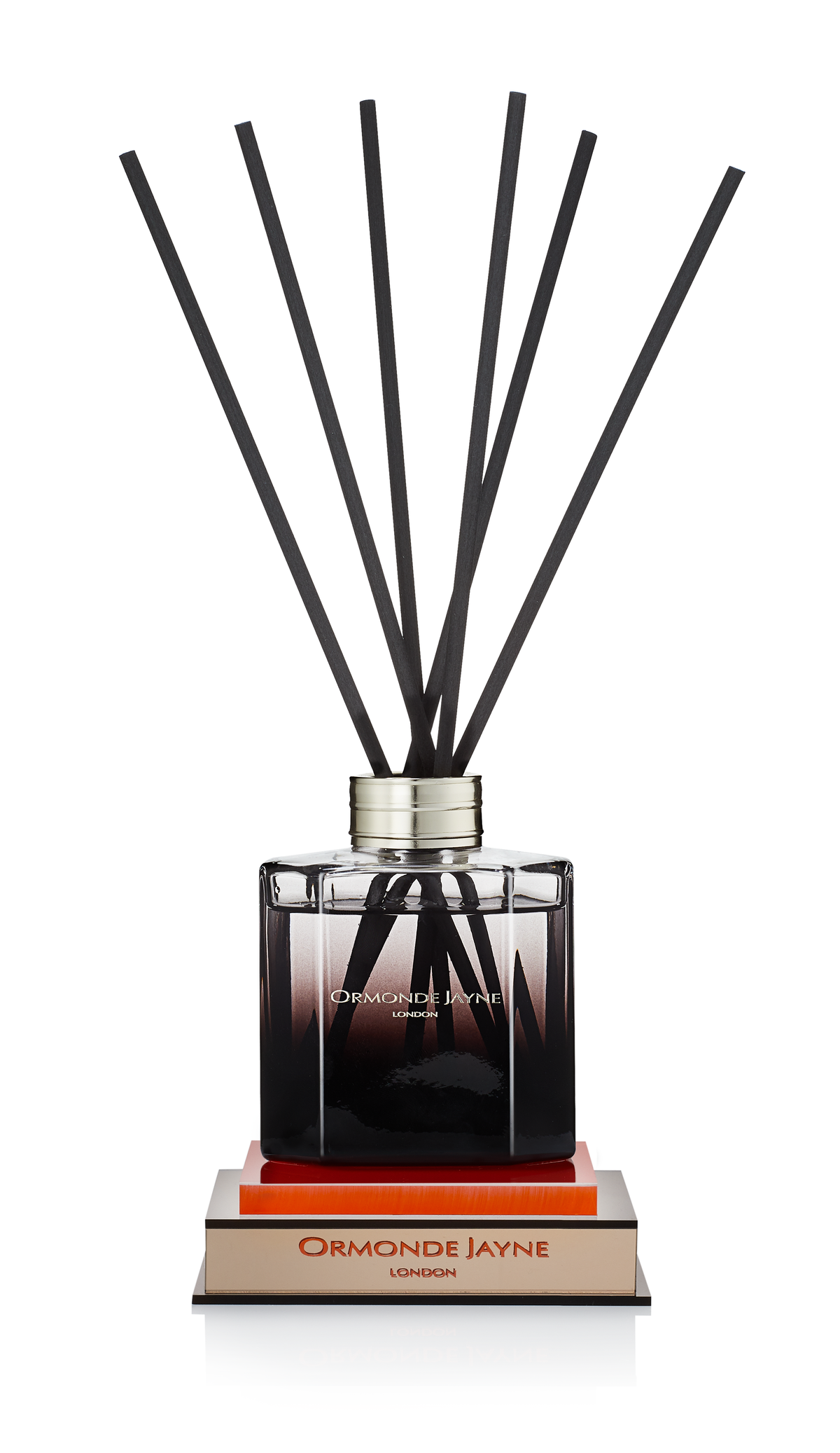 Ormonde Jayne reed diffuser with black sticks in a square glass bottle on stacked books
